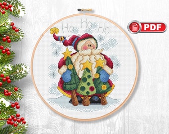 Op de afbeelding: Borduurpatroon met een cartoon kerstman die drie kerstboommetjes met sterren vasthoudt. Het patroon heeft de titel "Ho Ho Ho" en is beschikbaar als PDF-download.