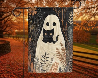 May include: A Halloween garden flag featuring a white ghost holding a black cat. The flag has a black background with floral and plant illustrations in shades of brown, beige, and green. The flag is displayed on a black metal garden stake.