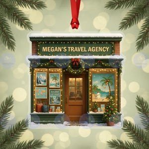 Pode incluir: Um enfeite de Natal em forma de fachada de agência de viagens. A placa diz "Megan's Travel Agency". As janelas exibem cartazes de viagens e uma cena tropical. Uma pequena árvore de Natal e uma grinalda decoram a frente. Uma fita vermelha pende do topo.