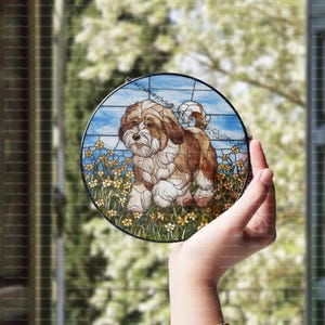 Puede incluir: Una ventana de vidrio emplomado colgante presenta un perro marrón y blanco con un fondo floral azul, verde y amarillo.