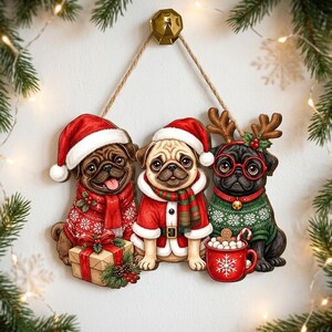 May include: A hanging wooden wall decoration featuring three pugs in Christmas attire. One pug wears a red sweater and Santa hat next to a gift box. The center pug wears a Santa suit. The third pug wears a green sweater, reindeer antlers, and red glasses next to a red mug.