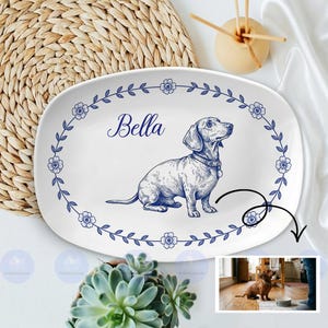 May include: White ceramic serving platter with a blue floral border and a detailed illustration of a dachshund dog. The name "Bella" is written in elegant script above the dog. A charming pet-themed decorative piece.