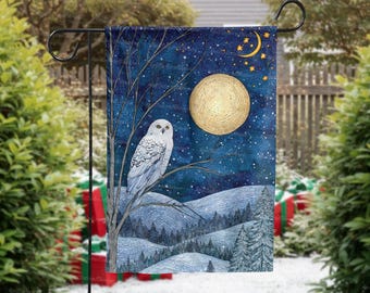 May include: A garden flag featuring a snowy owl perched on a tree branch, set against a night sky with a full moon and stars. The design includes a winter landscape with snow-covered hills and evergreen trees. The flag is displayed on a black metal stand.