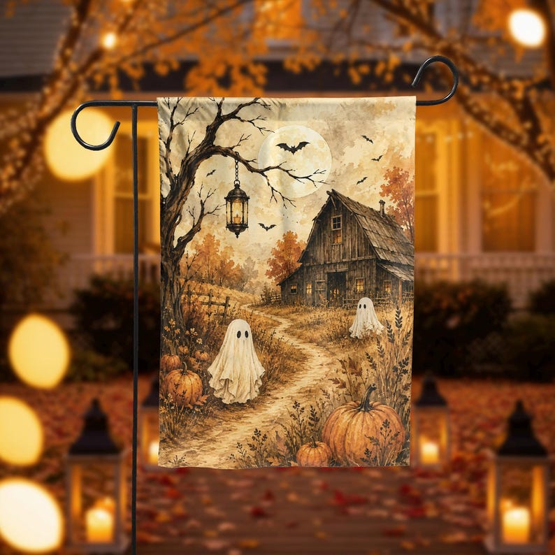 May include: A rectangular garden flag featuring a watercolor-style autumn scene with a rustic wooden barn, a winding dirt path, two white sheet ghosts, orange pumpkins, a hanging lantern from a bare tree, and a full moon with flying bats.