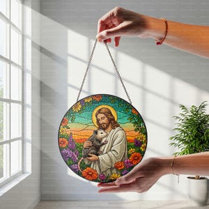 May include: A stained glass window hanging on a chain, depicting Jesus holding a possum. The background is a colorful landscape with flowers and a sunset.