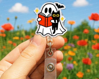 以下が含まれることがあります： ハロウィーンをテーマにしたバッジリール。赤い本を読む白い幽霊、黒猫、コウモリが描かれています。 バッジリールには透明なプラスチッククリップと格納式のコードが付いています。 背景は花の咲き乱れる野原です。