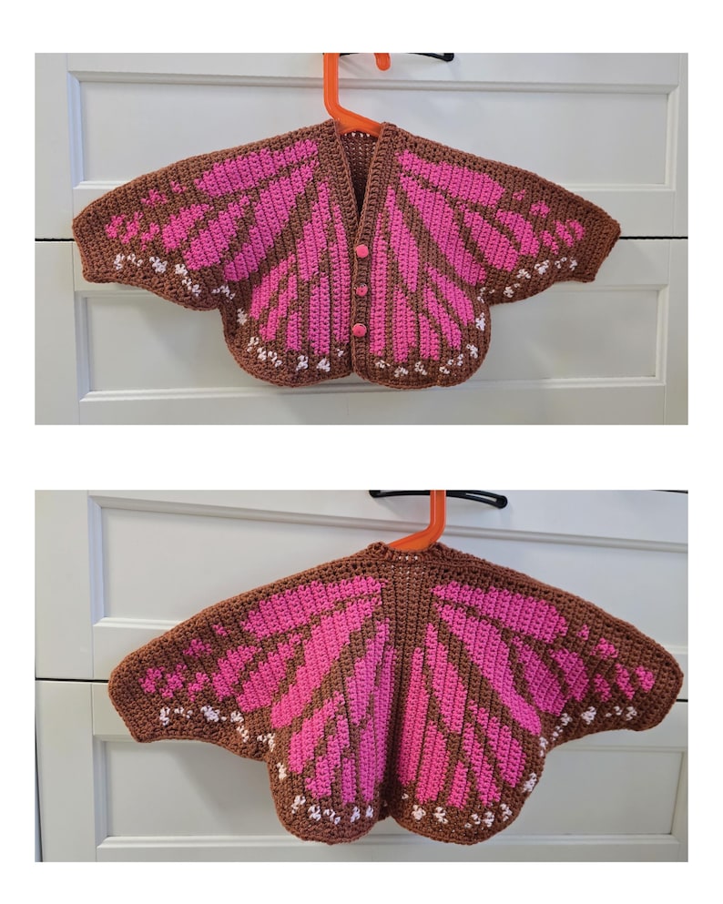 May include: A crochet cardigan featuring a brown and bright pink butterfly wing pattern with small white accents along the edges. The garment has a V-neckline, three pink buttons down the front, and wide, wing-shaped sleeves that extend outward.