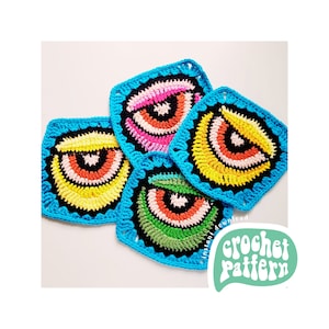May include: Four crocheted squares with colorful eye designs. Each square has a different color scheme, including pink, yellow, green, and orange. The squares are made with a blue border and are arranged in a pile.