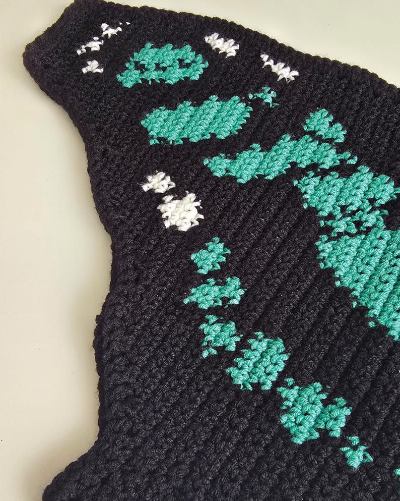 Close up tapestry crochet chart motif, malachite butterfly design in teal and black, crochet pattern detail
