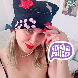 May include: Black crochet hat with red and pink floral accents. The hat features a unique design with openwork and a textured appearance. The image also includes the text "crochet pattern".