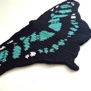 Close up tapestry crochet chart motif, malachite butterfly design in teal and black, crochet pattern detail