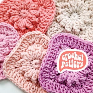 May include: Four crocheted squares in different shades of pink, from coral to lavender, with a sticker that says "crochet pattern" in a retro font.