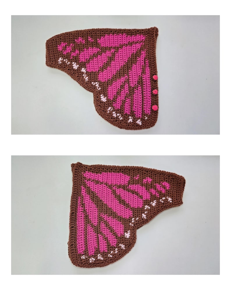 May include: A pair of crocheted butterfly wings in brown and bright pink. The wings feature a dark brown border with a pink interior pattern and small white accents along the outer edge. Three small pink buttons are attached to the side edge.