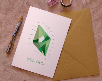 May include: A white card with a green geometric diamond shape with a white outline and white sun rays. The text "Sul Sul" is written in green below the diamond.