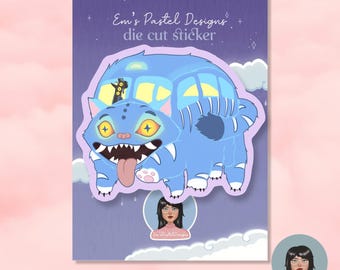 May include: A die-cut sticker featuring a blue cat-like creature with yellow eyes, a long tongue, and sharp teeth. The sticker has the text "Em's Pastel Designs" and "die cut sticker" on a purple background with clouds.