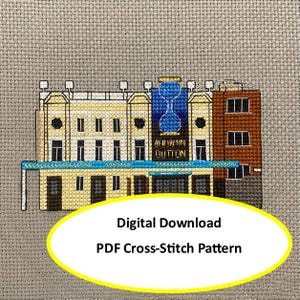 Puede incluir: Un patrón de punto de cruz que representa un edificio con un reloj de arena azul y el texto "BENJAMIN BUTTON". El edificio tiene una fachada beige, un toldo azul y una sección de ladrillo marrón. La imagen incluye el texto "Digital Download PDF Cross-Stitch Pattern".