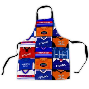 May include: A patterned apron with a collage of football shirts in blue, orange, and red. The shirts display team names including "FISONS" and "PIONEER". The apron has a black neck strap and ties, perfect for cooking.
