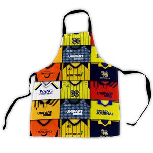 May include: An apron with a patchwork design of retro football shirts. The design includes logos and text such as "UNIPART," "LIONTRUST," and "SINGHA." The apron has a black neck strap and ties for the waist.