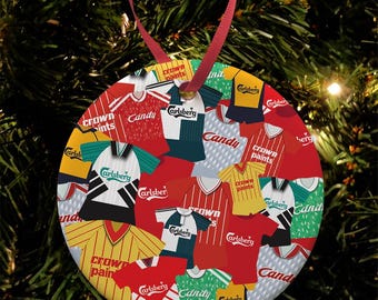 Può includere: Un addobbo natalizio rotondo con un collage di maglie da calcio vintage con vari sponsor, tra cui Carlsberg, Crown Paints e Candy. Le maglie sono di colore rosso, bianco, giallo, verde e blu.