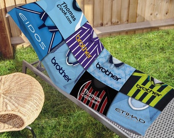 May include: A beach towel featuring a patchwork design of different soccer jerseys. The jerseys are in various colors, including blue, purple, black, yellow, and green. The jerseys have logos and text, including "Thomas Cook.com", "brother", "Etihad Airways", and "Eidos".