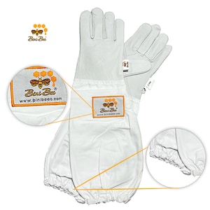 May include: White beekeeping gloves with long sleeves. The gloves have a leather palm and a fabric sleeve that extends up the arm. The Bini Bee logo is embroidered on the sleeve. The gloves are designed to protect the wearer from bee stings.