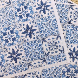 May include: Blue and white patterned paper napkins with a tile design. The napkins feature a repeating pattern of blue and white floral motifs.