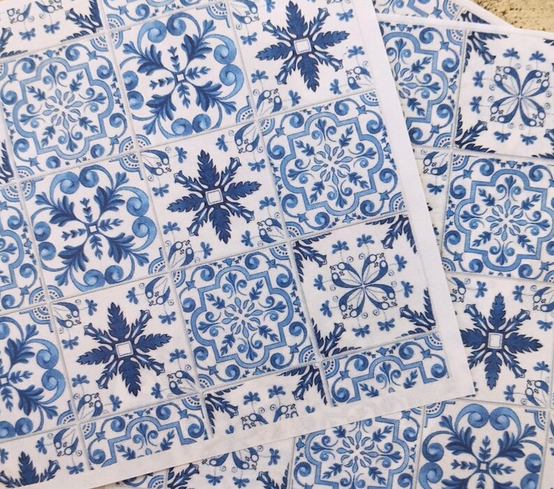 May include: Blue and white patterned paper napkins with a tile design. The napkins feature a repeating pattern of blue and white floral motifs.