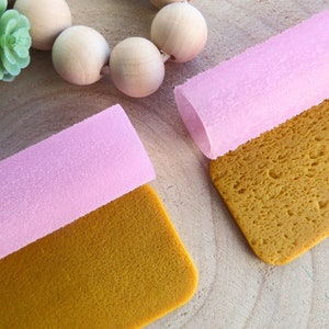 Peut inclure: Deux rouleaux texturés roses avec une surface texturée jaune en dessous. Les rouleaux sont faits d'un matériau souple et flexible et sont conçus pour l'artisanat et la création de textures uniques.