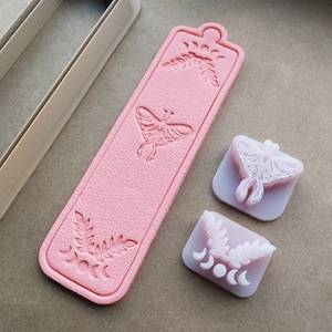 May include: Pink silicone moulds for crafting, featuring a moon and leaf design, a butterfly design, and a moon and leaf design with a crescent moon.