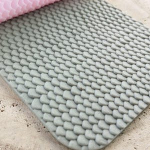 Könnte beinhalten: Nahaufnahme einer grauen, strukturierten Silikon-Backmatte mit einem Muster aus kleinen, überlappenden Kreisen. Die Matte ist so konzipiert, dass Lebensmittel nicht an Backblechen kleben bleiben.