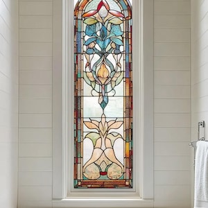 Puede incluir: Una bañera blanca con un grifo cromado y una ventana de vidrio emplomado encima. La ventana presenta un diseño floral colorido con tonos de azul, amarillo, rojo y verde.