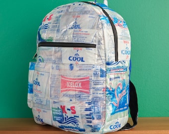 Può includere: Uno zaino blu e bianco realizzato con bottiglie d'acqua in plastica riciclate. Lo zaino ha un ampio scomparto principale e una tasca anteriore più piccola. Lo zaino è decorato con varie etichette e loghi di diversi marchi di bottiglie d'acqua.