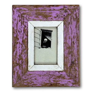 May include: Rectangular picture frame with a distressed, weathered look. The frame has a purple outer edge, a white inner edge, and a black and white photo of a person looking out a window. The frame is made of wood.