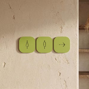 Könnte beinhalten: Drei quadratische, hellgrüne Wandschilder mit abgerundeten Ecken. Das erste Schild zeigt ein stilisiertes dreieckiges Symbol, das zweite ein rechteckiges Symbol und das dritte einen Pfeil nach rechts. Die Symbole sind in dünnen, dunkelgrauen Linien.