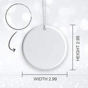 K&ouml;nnte beinhalten: Ein wei&szlig;er, runder Keramikschmuck mit einer Aufh&auml;ngeschnur. Der Schmuck ist 7,6 cm hoch und 7,6 cm breit. Ein Diagramm zeigt die Form des Schmucks. Der Hintergrund ist ein weiches, verschwommenes Muster aus Wei&szlig; und Silber.