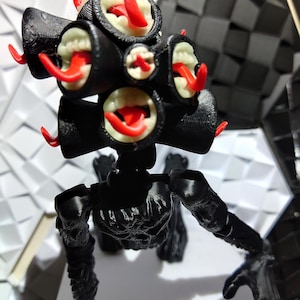 Puede incluir: Una figura negra articulada con múltiples estructuras similares a ojos, cada una con un interior blanco y una lengua roja que sobresale. La figura tiene una apariencia esquelética con extremidades detalladas y una superficie texturizada.