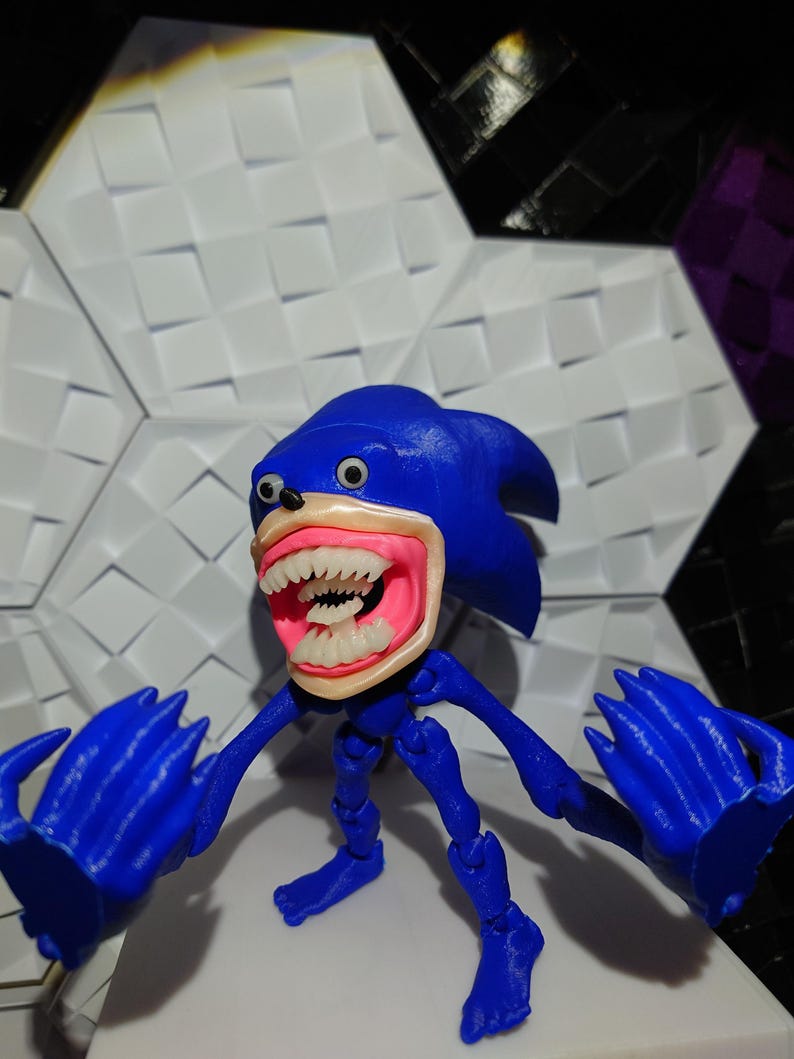 May include: A blue and pink articulated action figure of Sonic the Hedgehog with a creepy, exaggerated smile and large, white eyes.