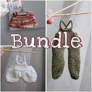 Peut inclure: Un lot de trois vêtements en tricot pour poupée, comprenant un pantalon salopette vert et marron, un pantalon salopette blanc et une robe multicolore. Les vêtements sont suspendus à des cintres.