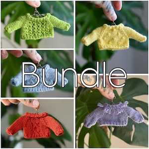 Peut inclure: Un ensemble de mini-pulls tricotés de différentes couleurs : vert, jaune, bleu, orange et violet. Chaque pull est suspendu à un petit cintre métallique. Le mot "Bundle" est affiché en blanc sur l'image.