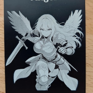May include: A black rectangular game card featuring the white text Angel at the top. The center displays a monochrome illustration of a winged warrior in armor holding a sword. The bottom includes the text Flying, Token Creature- Angel, and 4/4.