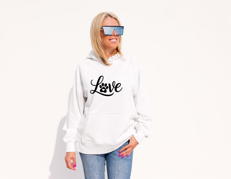 May include: White hoodie with a front pocket and the word "Love" in a black script font, with a paw print replacing the "o". The hoodie is paired with blue jeans.