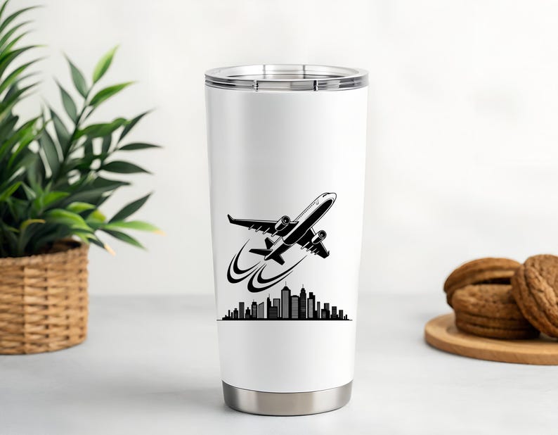 May include: A white travel tumbler with a black and white graphic of an airplane taking off over a city skyline. The tumbler has a silver base and a silver lid. The design is printed on the front of the tumbler.