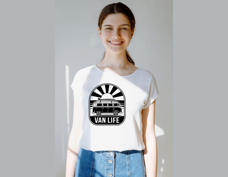 May include: White t-shirt with a black and white graphic of a vintage van, sun, and the words "VAN LIFE". The shirt is made of a soft material and is suitable for casual wear.