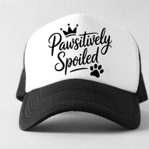 May include: A black and white trucker hat with the text "Pawsitively Spoiled" in a script font, a crown, and a paw print. The hat has a white front panel and a black mesh back.