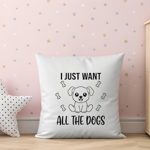 May include: White square pillow with the text "I JUST WANT ALL THE DOGS" and a cartoon dog illustration. The pillow is surrounded by a star-patterned wall and a star-shaped pillow.