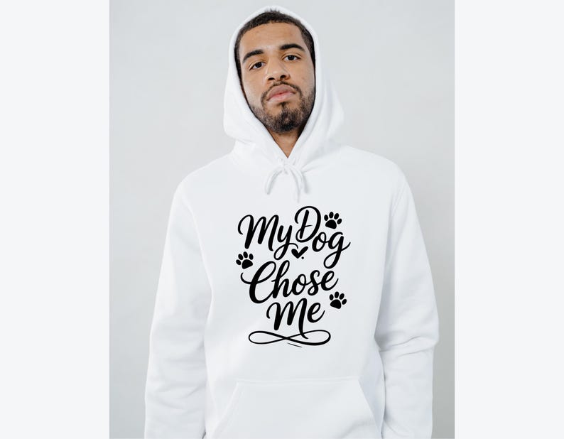 May include: White hooded sweatshirt with the text "My Dog Chose Me" in black script. The design includes paw prints and a heart. The sweatshirt has a drawstring hood and a front pocket.