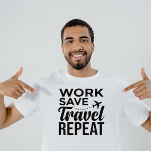 May include: White t-shirt with the text "WORK SAVE TRAVEL REPEAT" in black. A small airplane graphic is above the word "travel". The person in the image is pointing at the shirt.