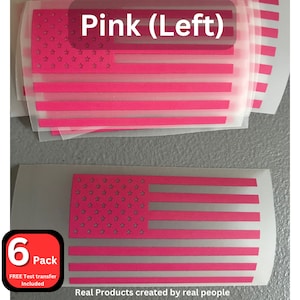 May include: A pack of six pink and white American flag iron-on vinyl decals. The decals are on a clear sheet with a white background. The text "6 Pack" and "FREE Test transfer Included" is on a red label in the lower left corner. The text "Pink (Left)" is in the upper right corner. The text "Real Products created by real people" is in the lower right corner.