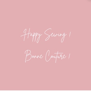 K&ouml;nnte beinhalten: Ein hellrosa Hintergrund mit den Worten "Happy Sewing!" und "Bonne Couture!" in wei&szlig;er Schrift. Das Bild ist ein einfaches, aber stilvolles Design.