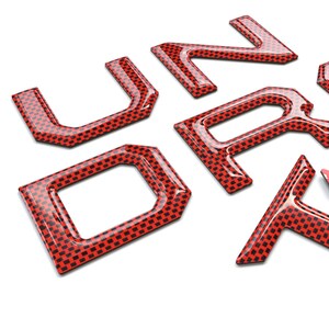Pu&ograve; includere: Lettere 3D rosse che compongono la parola "Tundra" con un motivo in fibra di carbonio. Le lettere sono vendute singolarmente e sono progettate per essere utilizzate come sostituzione delle lettere di fabbrica di una Toyota Tundra.